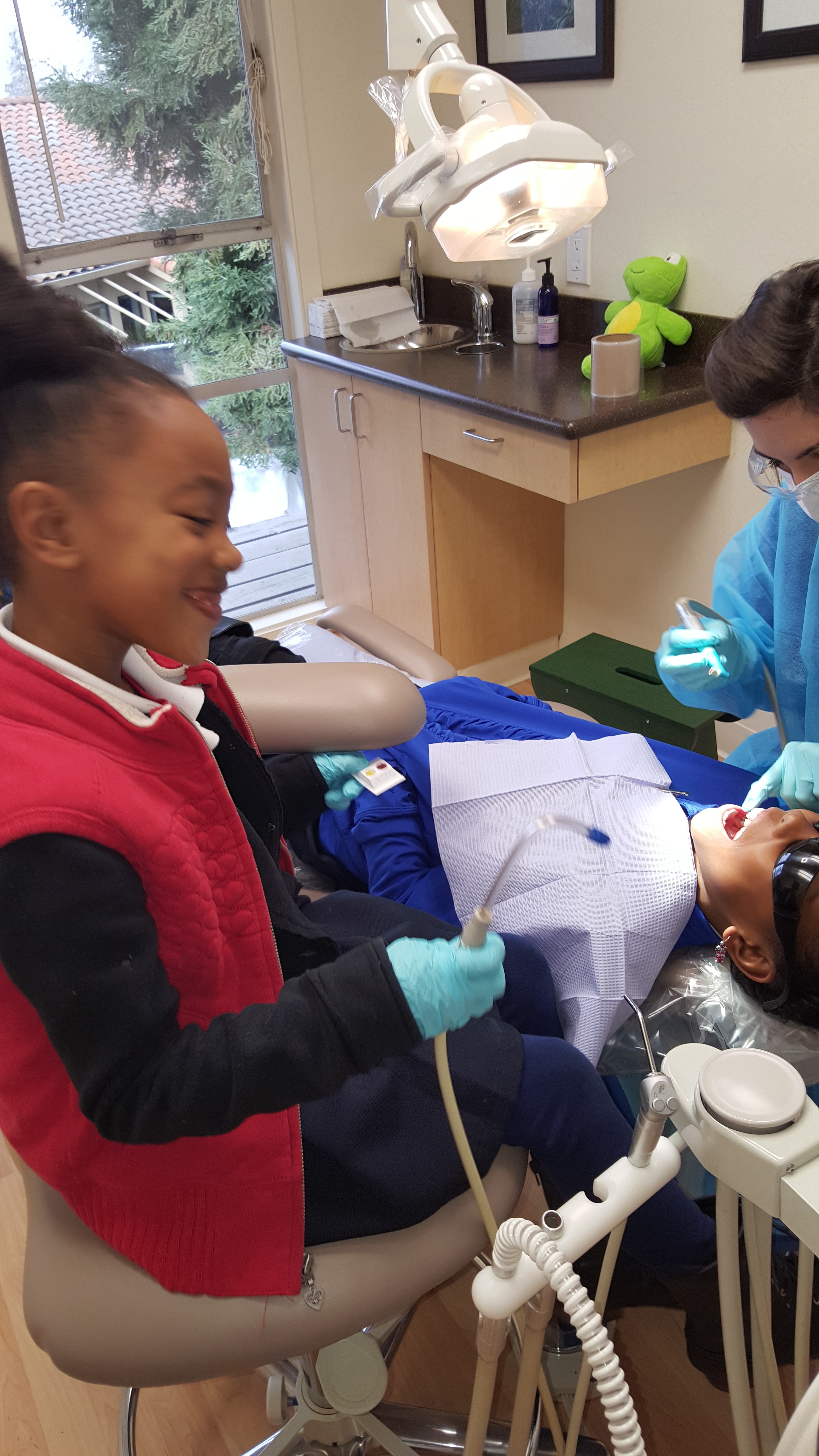 Aspiring dentist helping with sister's appointment